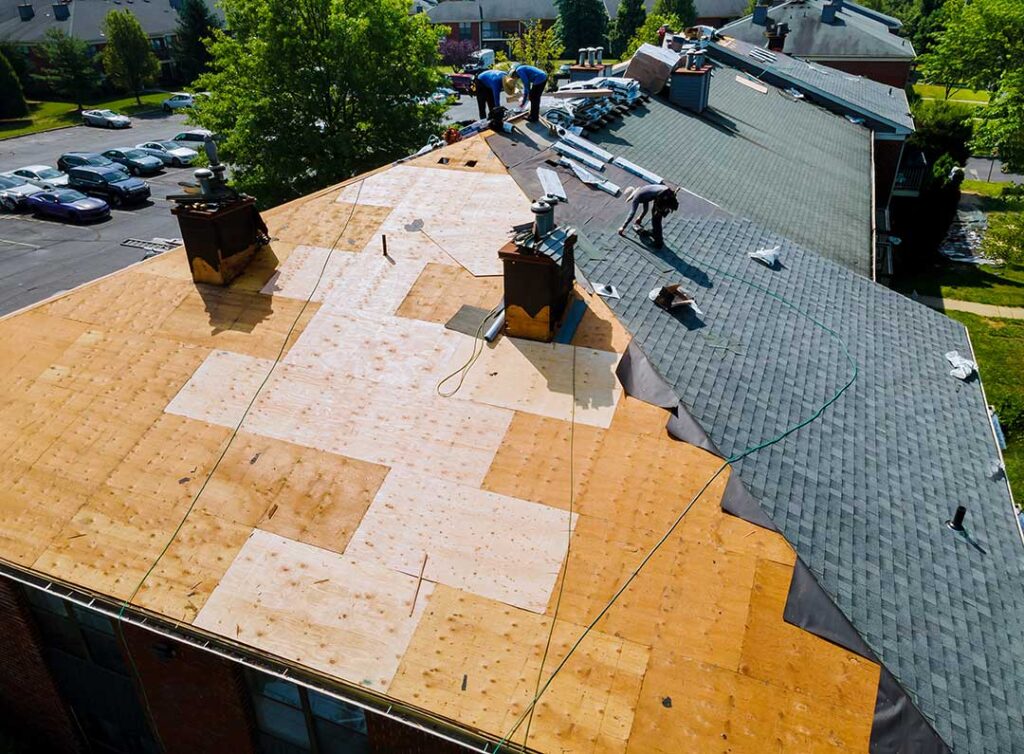 Homeowner safely photographs missing shingles and an interior ceiling stain after a storm.